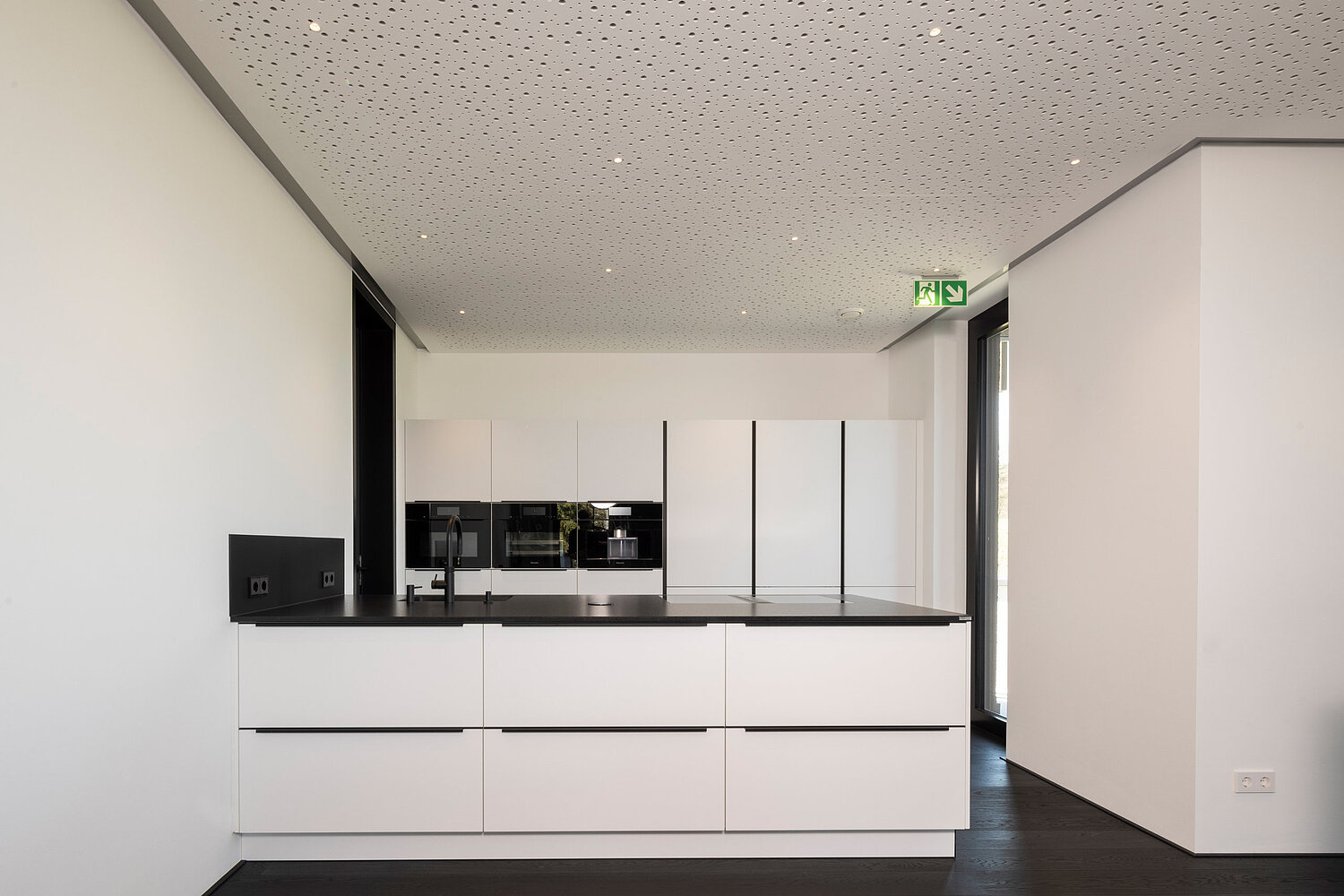 Minimalistische weiße Küche von Lorinser Schlichte weiße Küche mit klaren Fronten und reduziertem Design, geplant vom Küchenstudio Lorinser