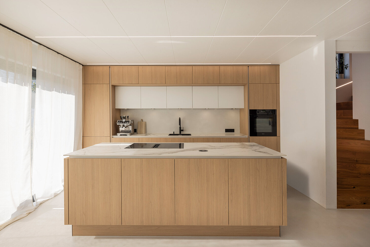 Moderne Küche mit Holzfronten von Lorinser Helle Einbauküche mit Holzfronten, Kücheninsel und offenen Regalen vom Küchenstudio Lorinser